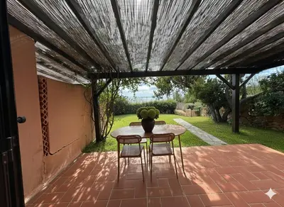 a patio with a table and chairs under a pergola at 8 ARBOUSIERS villa 13 in Bonifacio