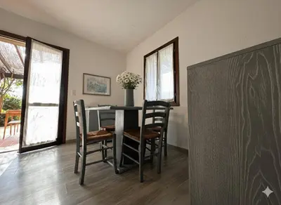 a dining room with a table and chairs and a chalkboard at 8 ARBOUSIERS villa 13 in Bonifacio