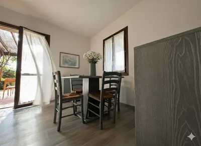 a dining room with a table and chairs and a chalkboard at 8 ARBOUSIERS villa 13 in Bonifacio