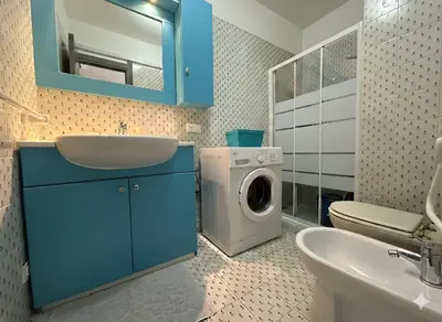 a bathroom with a washing machine and a sink at 8 ARBOUSIERS villa 13 in Bonifacio