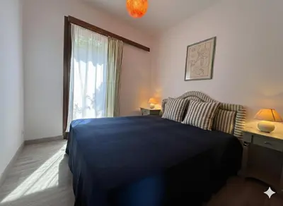 a bedroom with a blue bed and a window at 8 ARBOUSIERS villa 13 in Bonifacio