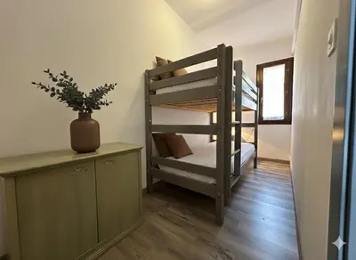 a room with a bunk bed and a desk with a plant at 8 ARBOUSIERS VILLA 12 in Bonifacio