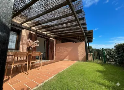 a patio with a table and chairs on a lawn at 8 ARBOUSIERS VILLA 12 in Bonifacio