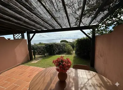 a vase of flowers sitting on a table on a patio at 8 ARBOUSIERS VILLA 12 in Bonifacio