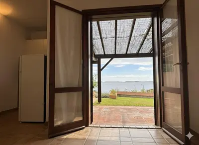 an open door to a kitchen with a view of the ocean at 8 ARBOUSIERS VILLA 21 in Bonifacio