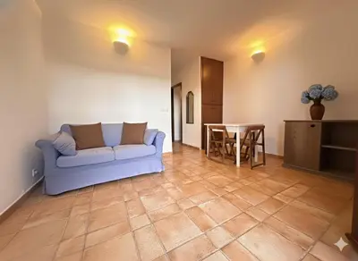 a living room with a couch and a table at 8 ARBOUSIERS VILLA 21 in Bonifacio