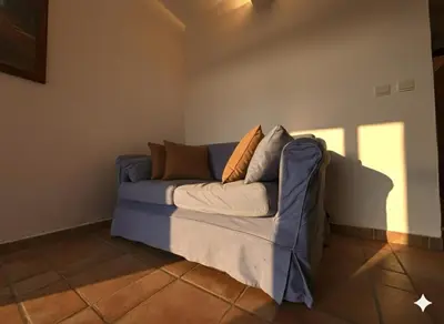 a living room with a blue couch with pillows on it at 8 ARBOUSIERS VILLA 21 in Bonifacio