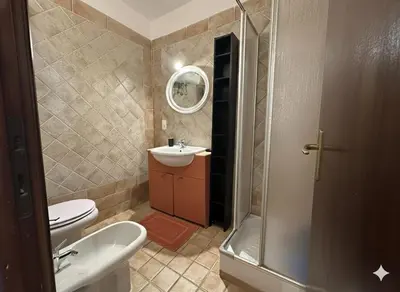 a bathroom with a toilet and a sink and a shower at 8 ARBOUSIERS VILLA 20 in Bonifacio