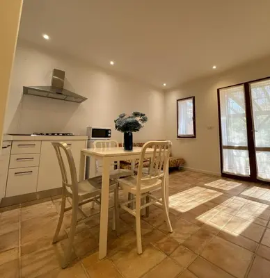 a kitchen with a table and chairs in a room at 8 ARBOUSIERS VILLA 20 in Bonifacio