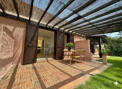 an outdoor patio with a wooden pergola at 8 ARBOUSIERS VILLA 20 in Bonifacio