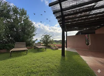two benches sitting on the grass in a yard at 8 ARBOUSIERS VILLA 20 in Bonifacio
