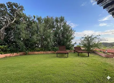 two benches sitting on the grass in a yard at 8 ARBOUSIERS VILLA 20 in Bonifacio
