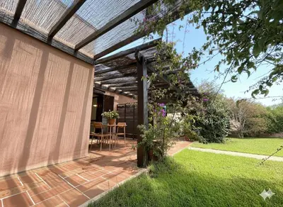 a patio with a pergola and a table in a yard at 8 ARBOUSIERS VILLA 19 in Bonifacio