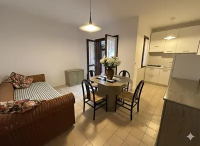 a living room with a couch and a table with chairs at 8 ARBOUSIERS VILLA 19 in Bonifacio
