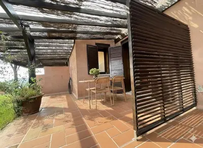a patio with a wooden pergola and a table at 8 ARBOUSIERS VILLA 19 in Bonifacio