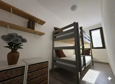 a room with bunk beds and a vase with a plant at 8 ARBOUSIERS VILLA 17 in Bonifacio