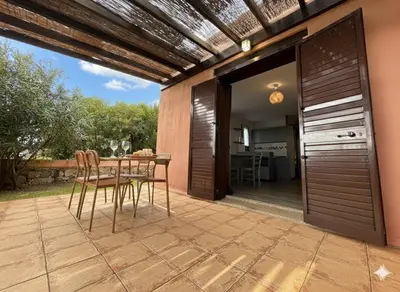 a patio with a table and chairs and a kitchen at 8 ARBOUSIERS VILLA 17 in Bonifacio