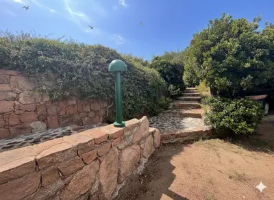 a stone wall with a green pole on it at 8 ARBOUSIERS VILLA 17 in Bonifacio