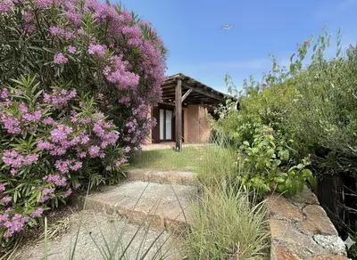 a garden with flowers in front of a house at 8 ARBOUSIERS VILLA 17 in Bonifacio