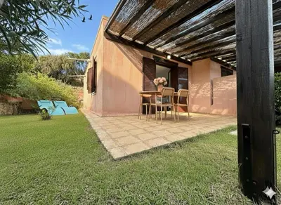 a patio with a table and chairs in a yard at 8 ARBOUSIERS VILLA 17 in Bonifacio
