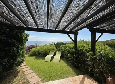 two benches under a pergola with a view at 8 ARBOUSIERS VILLA 16 in Bonifacio