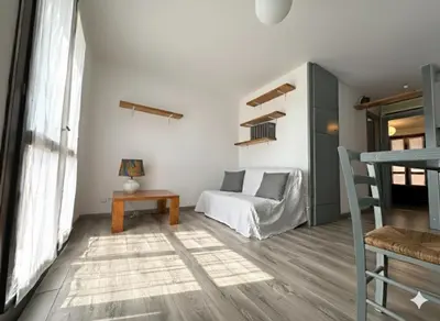 a living room with a bed and a table at 8 ARBOUSIERS VILLA 16 in Bonifacio