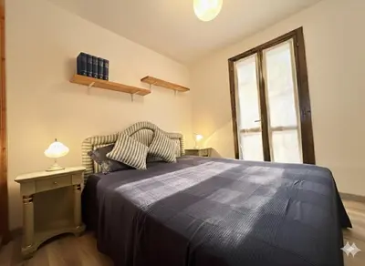 a bedroom with a large bed and a window at 8 ARBOUSIERS VILLA 16 in Bonifacio