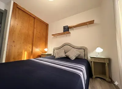 a bedroom with a blue bed and a wooden door at 8 ARBOUSIERS VILLA 16 in Bonifacio