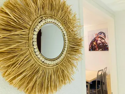 a gold wreath hanging on a wall with a mirror at Appartement VAIANA avec piscine en bord de mer in Ajaccio