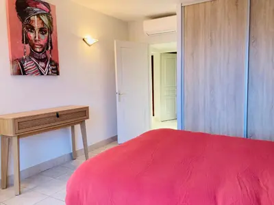 a bedroom with a red bed and a desk at Appartement VAIANA avec piscine en bord de mer in Ajaccio