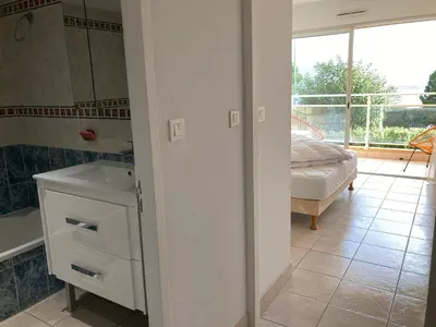 a bathroom with a sink and a tub and a mirror at Appartement VAIANA avec piscine en bord de mer in Ajaccio