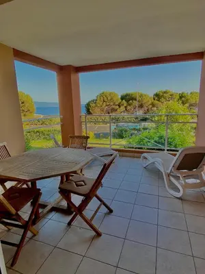 a dining room with a table and chairs and a balcony at AJACCIO les iles sanguinaires in Ajaccio