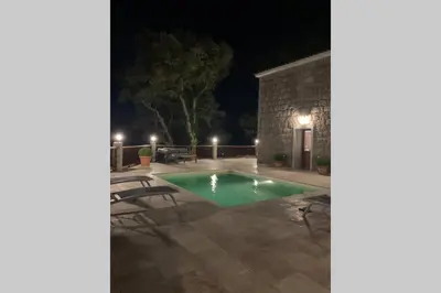 a swimming pool in a yard at night at Maison typique de campagne au cœur de la nature . in Sartène