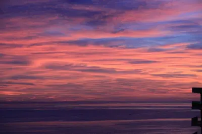 a sunset over the ocean with a pink at AjaccioPanoramicView in Ajaccio