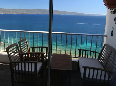 a balcony with chairs and a view of the ocean at AjaccioPanoramicView in Ajaccio