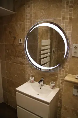 a bathroom with a sink and a round mirror at AjaccioPanoramicView in Ajaccio