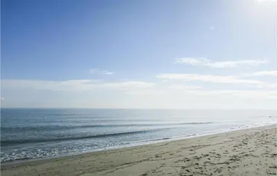 a beach with footprints in the sand and the ocean at 1 Bedroom Gorgeous Home In Venzolasca in Venzolasca