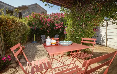a picnic table and chairs in a yard with flowers at 1 Bedroom Gorgeous Home In Venzolasca in Venzolasca
