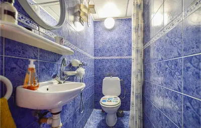 a blue tiled bathroom with a sink and a toilet at 1 Bedroom Gorgeous Home In Venzolasca in Venzolasca