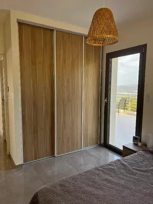 a bedroom with a large sliding glass door with a window at Villa Cargese in Cargèse