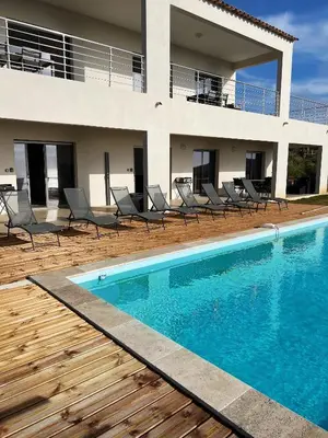 a swimming pool in front of a house at Villa Cargese in Cargèse