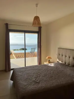 a bedroom with a bed and a view of the ocean at Appartement 4A villa cargese in Cargèse