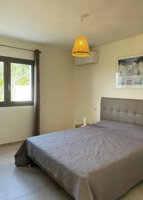 a bedroom with a large bed and a window at Appartement 4A villa cargese in Cargèse