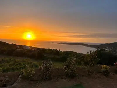a sunset over the ocean with the sun setting in the sky at Appartement 4A villa cargese in Cargèse