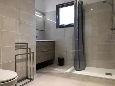 a bathroom with a shower and a toilet and a window at Appartement 4A villa cargese in Cargèse