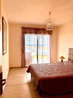 a bedroom with a bed and a large window at Appartement 4A villa cargese in Cargèse