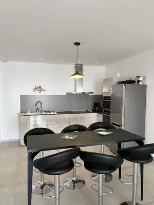 a kitchen with a black table and black chairs at Appartement 4A villa cargese in Cargèse