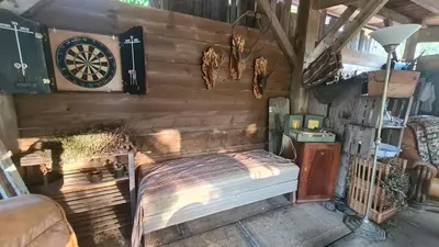 a bedroom with a bed and a dartboard on the wall at Gîte atypique Le Pod au coeur du maquis in Carbuccia