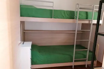 a bunk bed with a ladder in a room at Appartement les pieds dans l'eau 300 m plage - 2 piscines in Linguizzetta