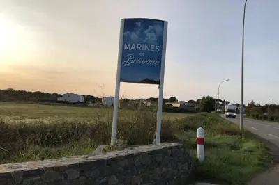 a blue sign on the side of a road at Appartement les pieds dans l'eau 300 m plage - 2 piscines in Linguizzetta